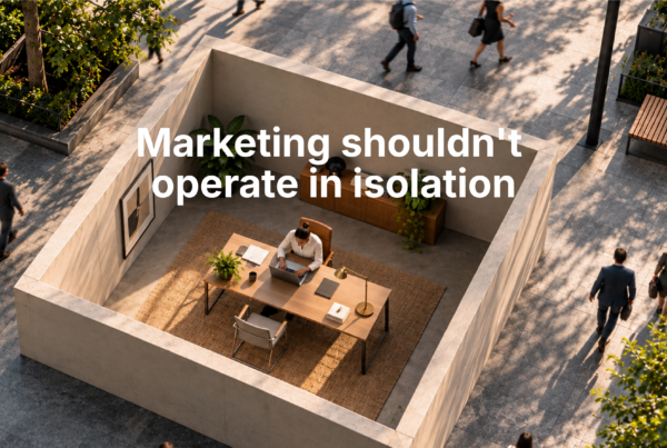 Marketer working inside four walls while people move around outside, representing the strategic role of marketing in understanding the wider market.